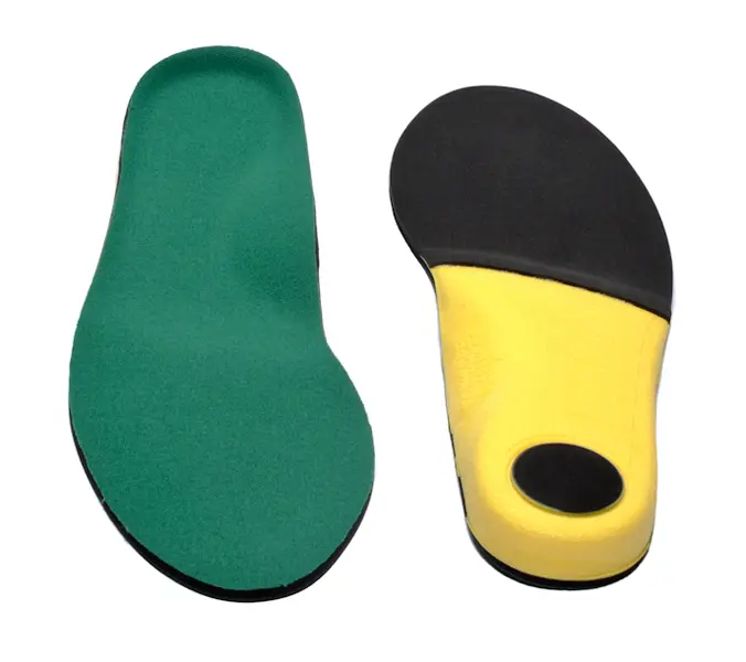 A pair of shoes with different colored soles.